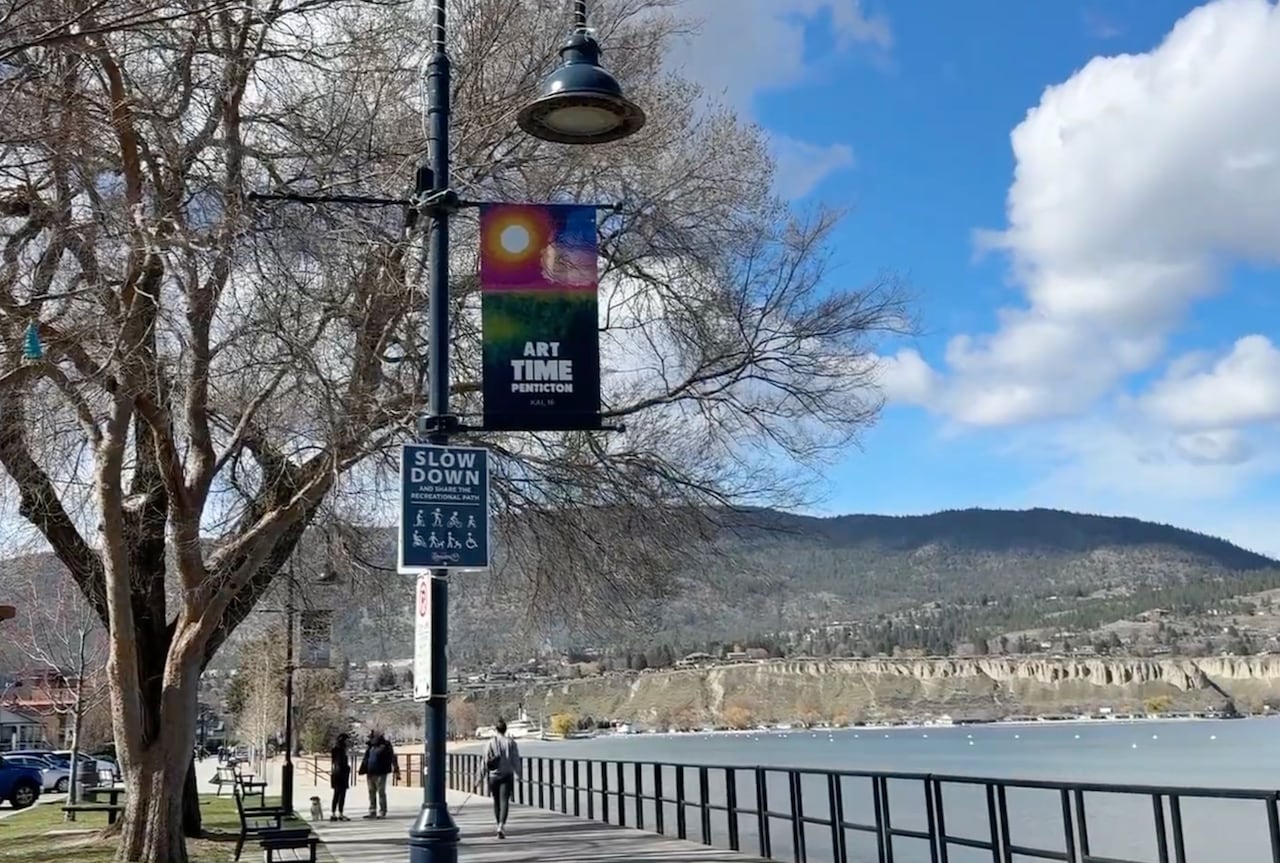 A colourful street banner hangs off a lamp post.