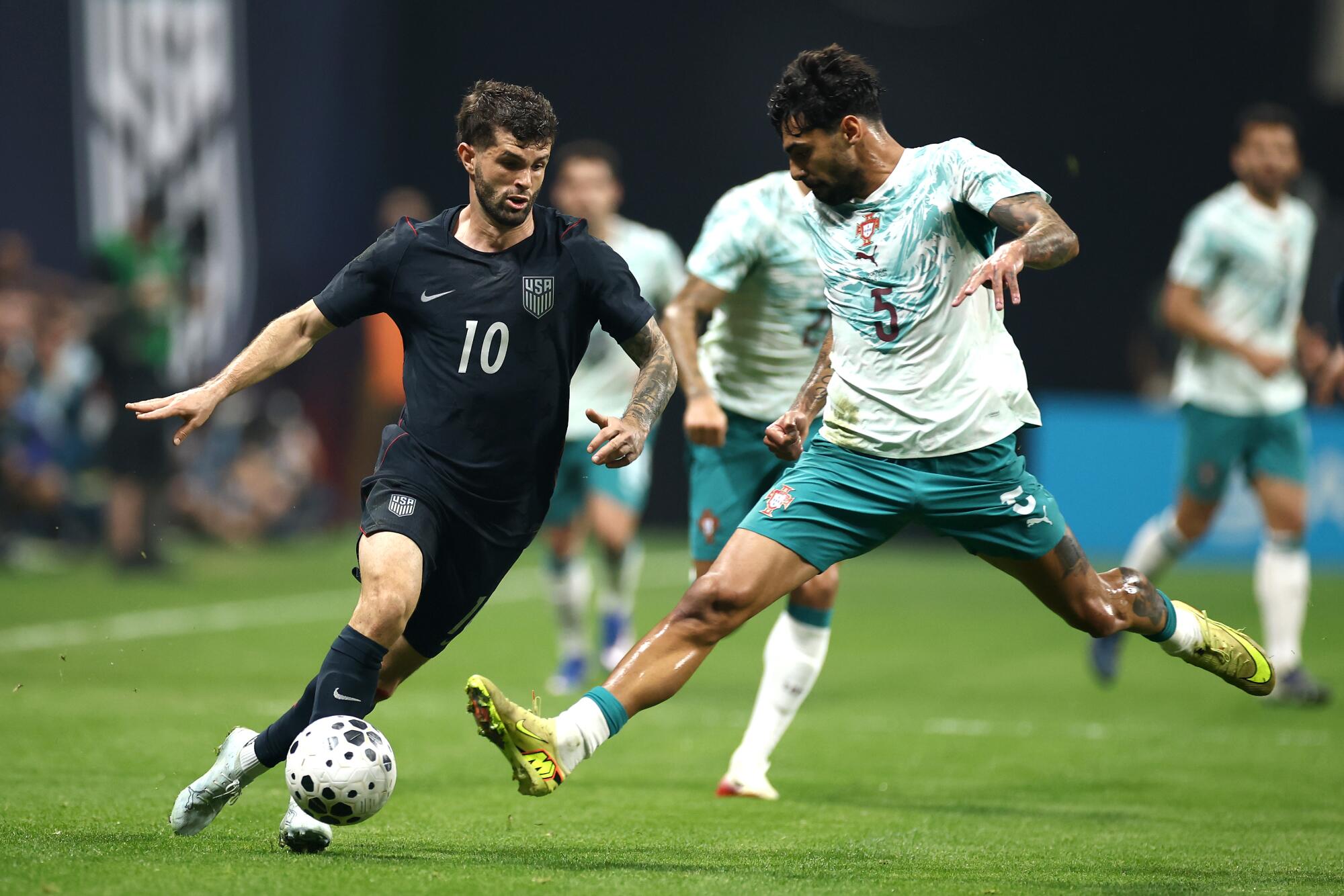 Christian Pulisic, left, controls the ball during an international friendly against Portugal on March 31.