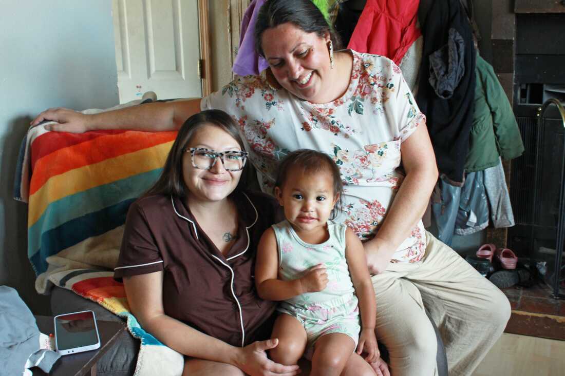 Doula Misty Pipe sits behind her client, Britney WolfVoice, and WolfVoice’s youngest daughter, Ellie WolfVoice. Pipe first started working with the mom during her pregnancy with Ellie. Britney says that because of Pipe’s support, the birth of her youngest daughter was the first time she felt at peace in a hospital.
