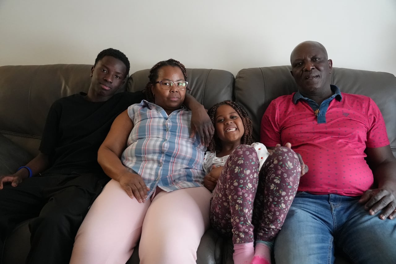 A family sits on the couch. 