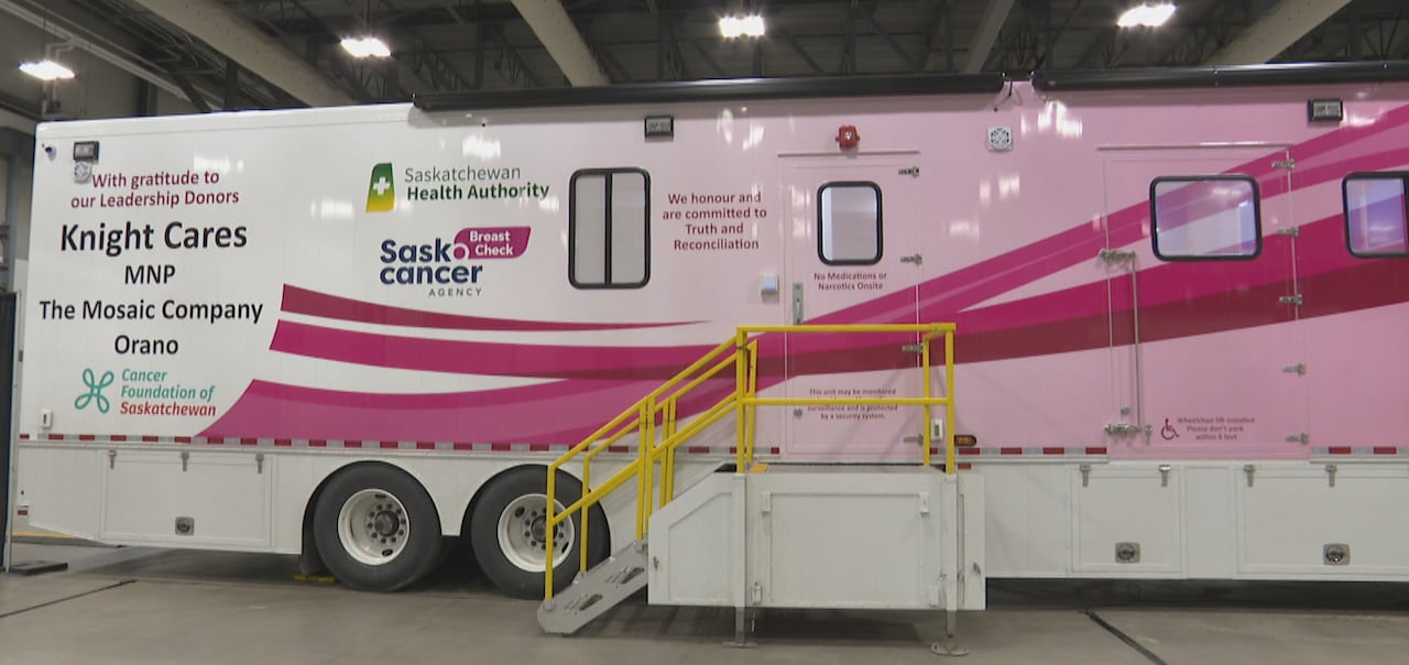 A semi trailer painted pink with various logos