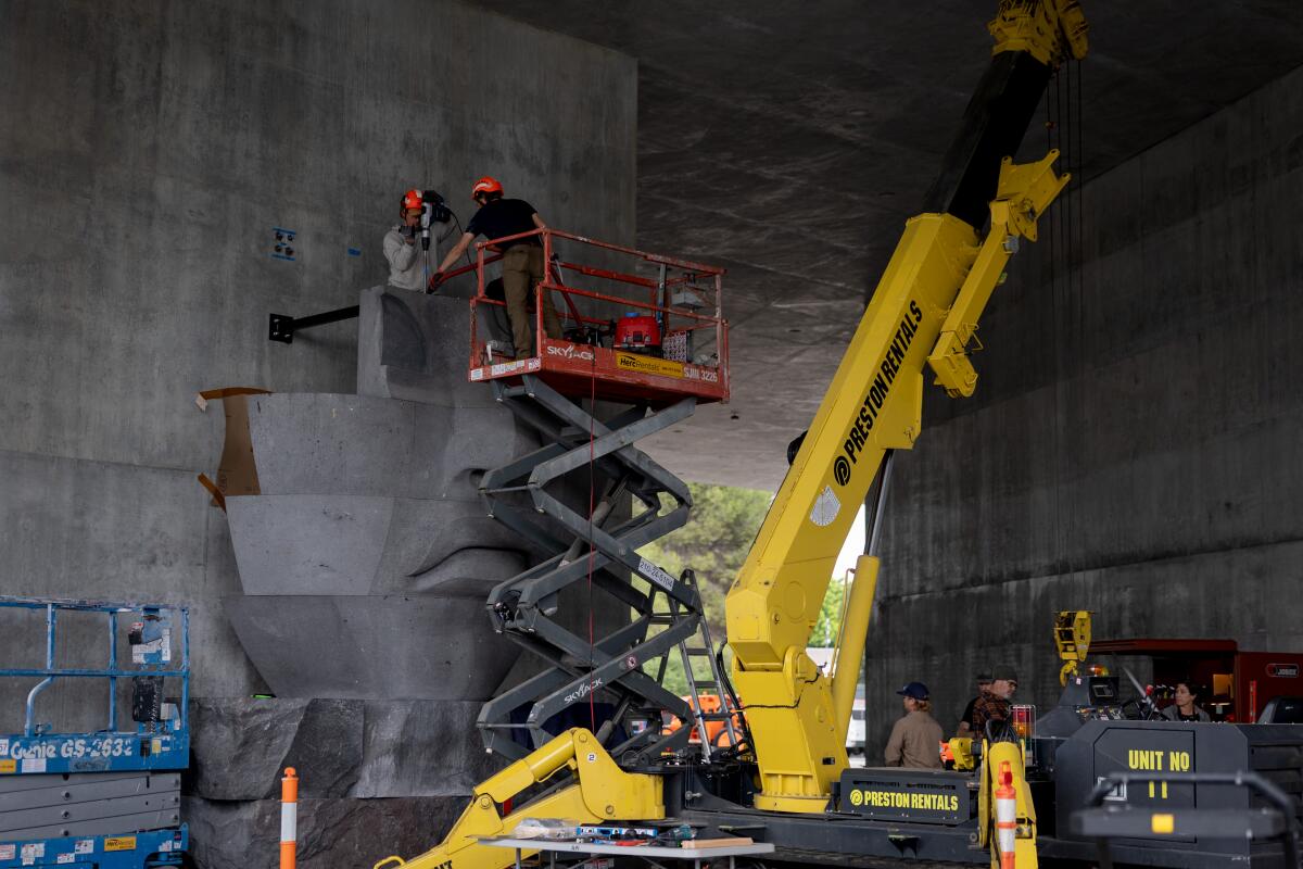 A crew installs artwork at the David Geffen Galleries.