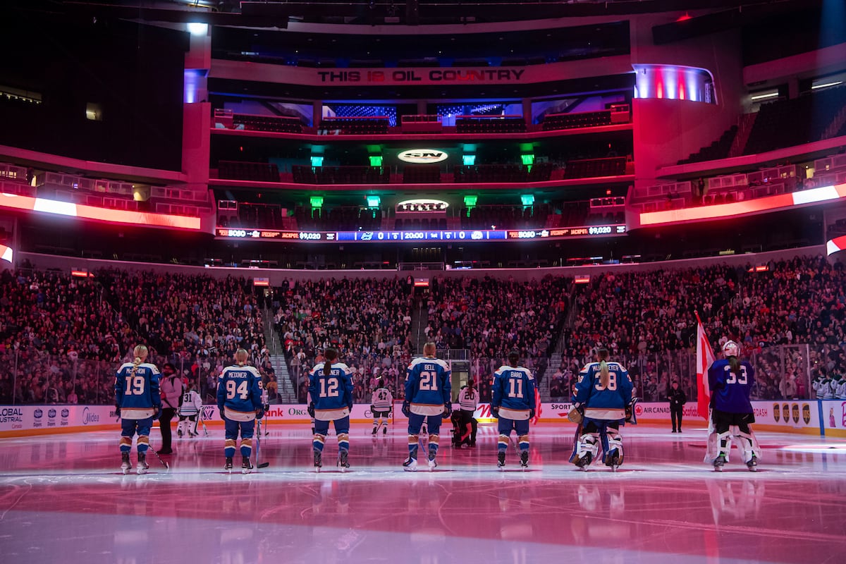 Hockey players are lined up on the ice.