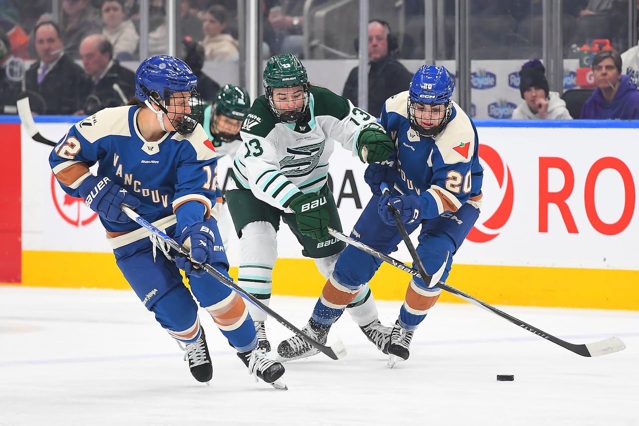 Hockey players battle for the puck during a game.