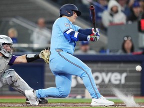 Toronto Blue Jays' Daulton Varsho fouls off a pitch in front of Colorado Rockies catcher Hunter Goodman during a game earlier this season.
