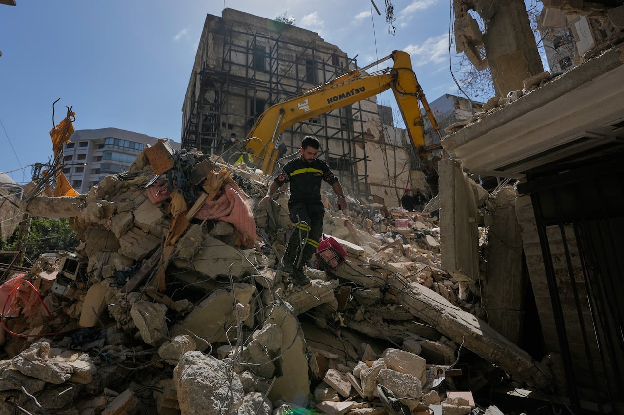A Lebanese civil defense worker walks on the rubble of a building destroyed in an Israeli airstrike a day earlier in Beirut, Lebanon, Thursday, April 9, 2026. (AP Photo/Hussein Malla)