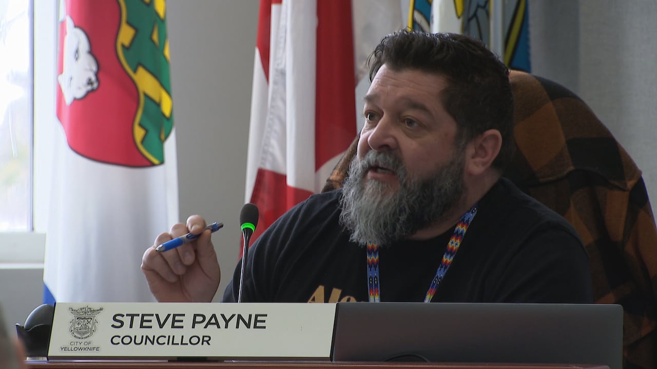 A man sitting holding a pen