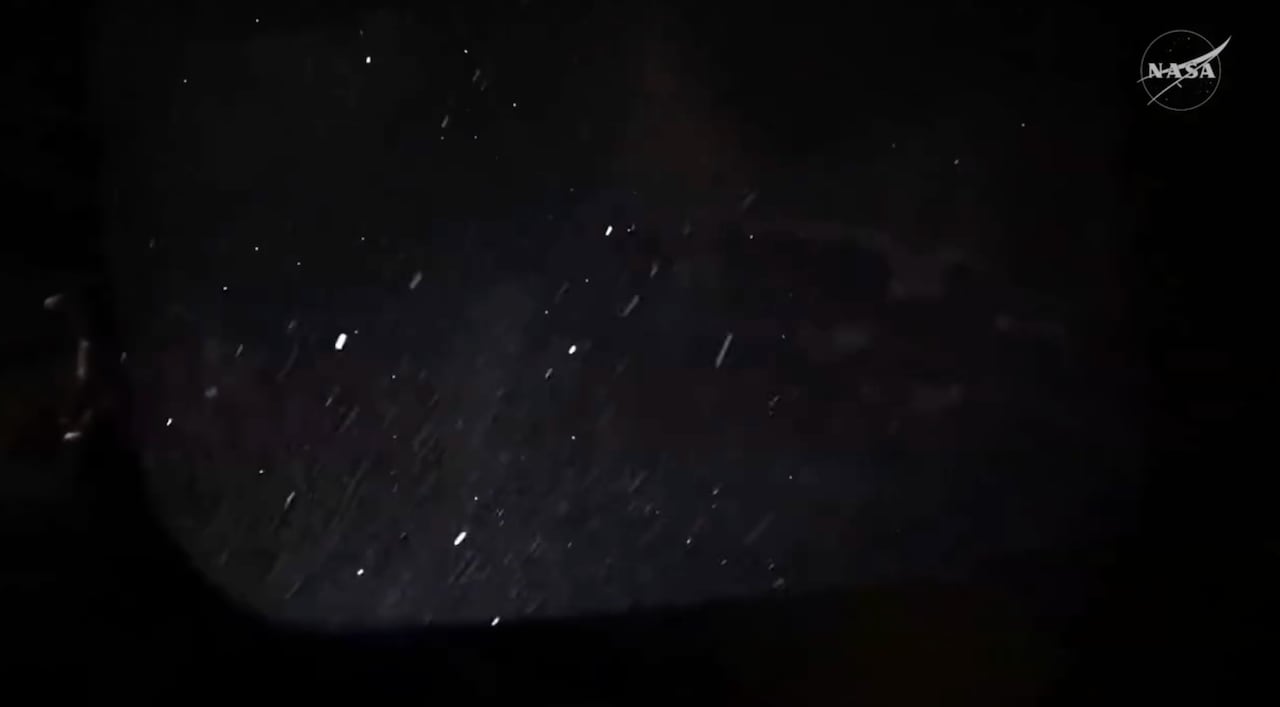 Streaks of white stream past a window staring out into the blackness of space. 