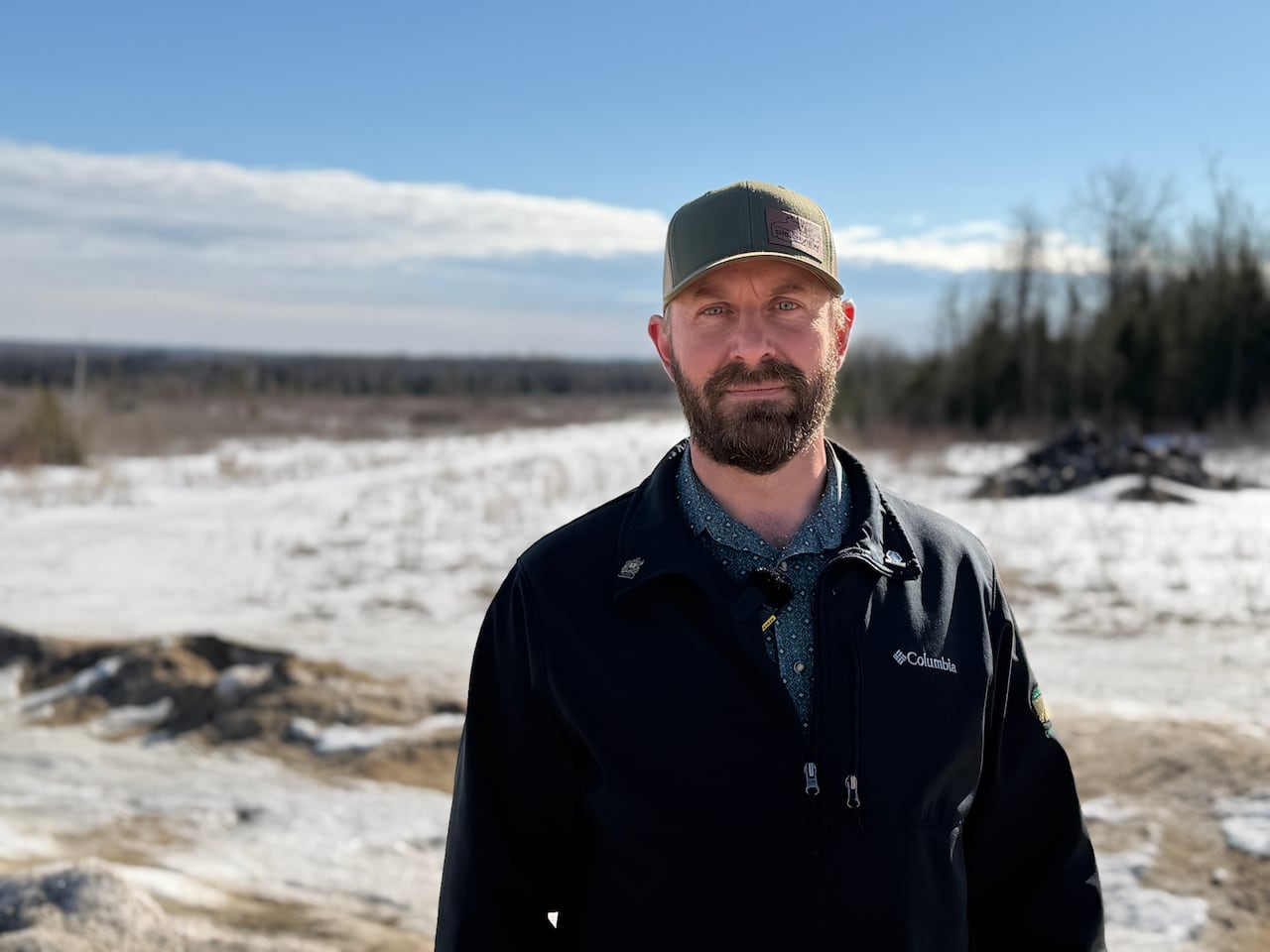 Ryan Ratzlaff stands in front of a snowy trail.