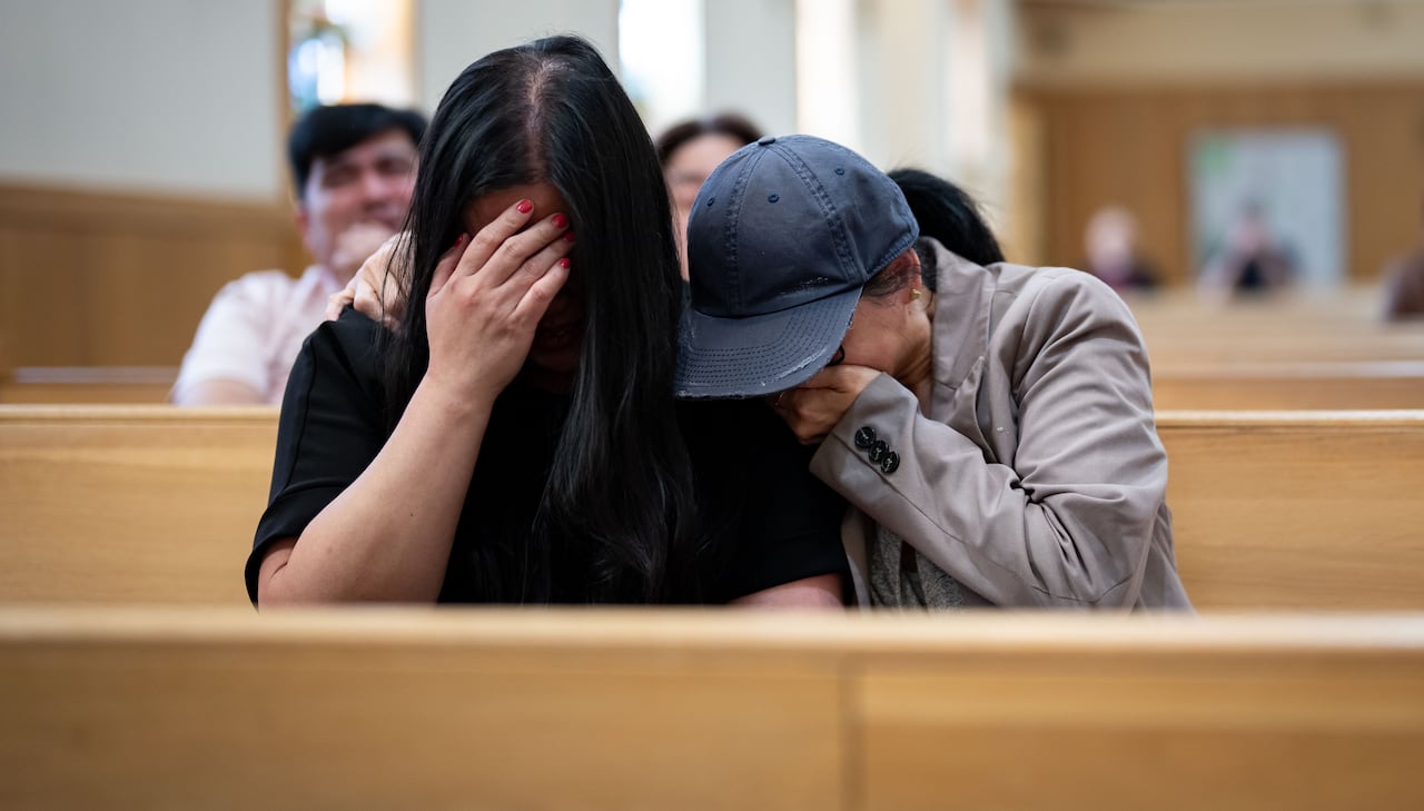 People cry in church pews.