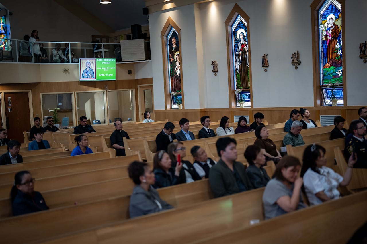Dozens of people are seen in church pews.