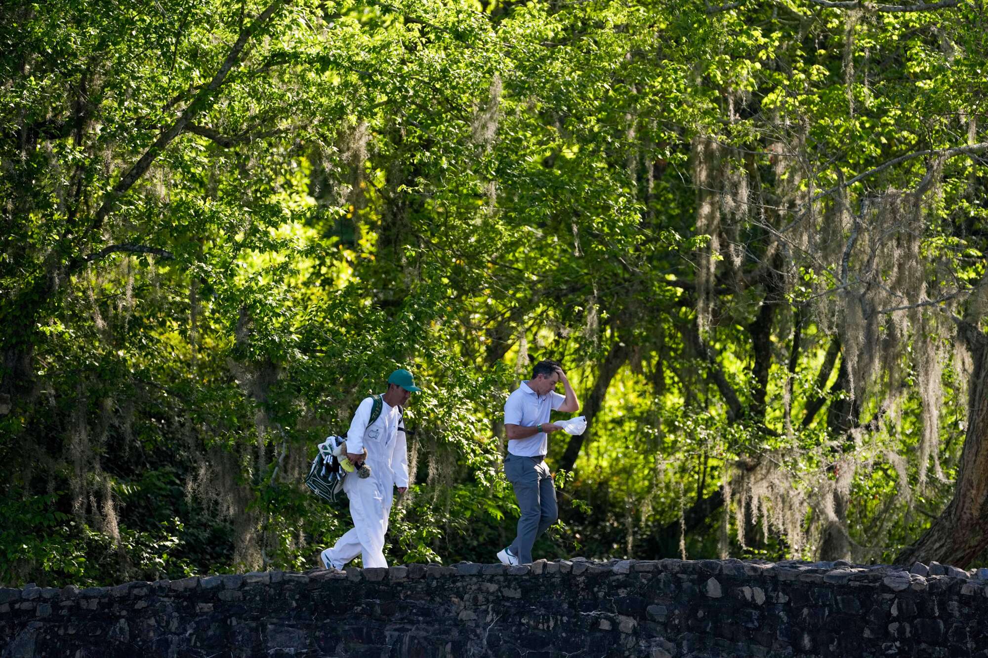 Rory McIlroy, of Northern Ireland, walk across the Nelson Bridge.