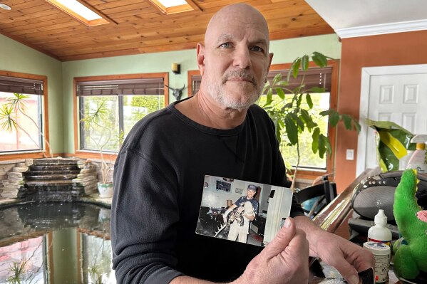 Tony Cavallaro holds a photo of his pet alligator, Albert, on March 19, 2024, in Hamburg, N.Y. (AP Photo/Carolyn Thompson, File)