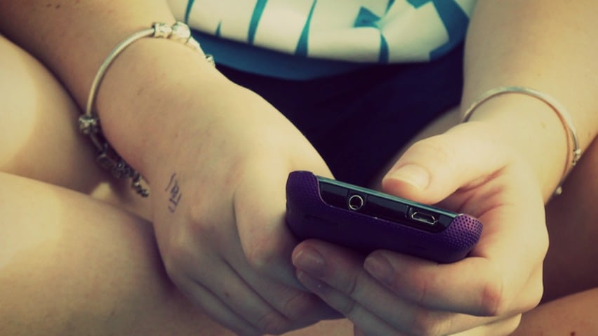 A person is sitting with a phone in their hands.