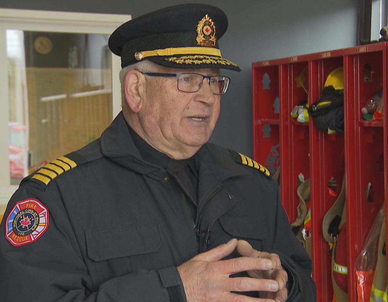 A man wears a fire captain's uniform. 