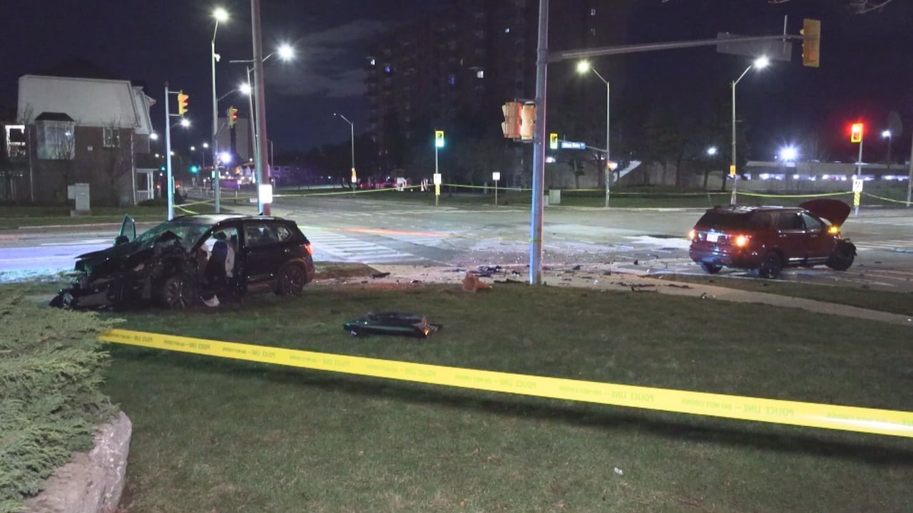 Smashed up cars on curb of intersection taped off by police tape