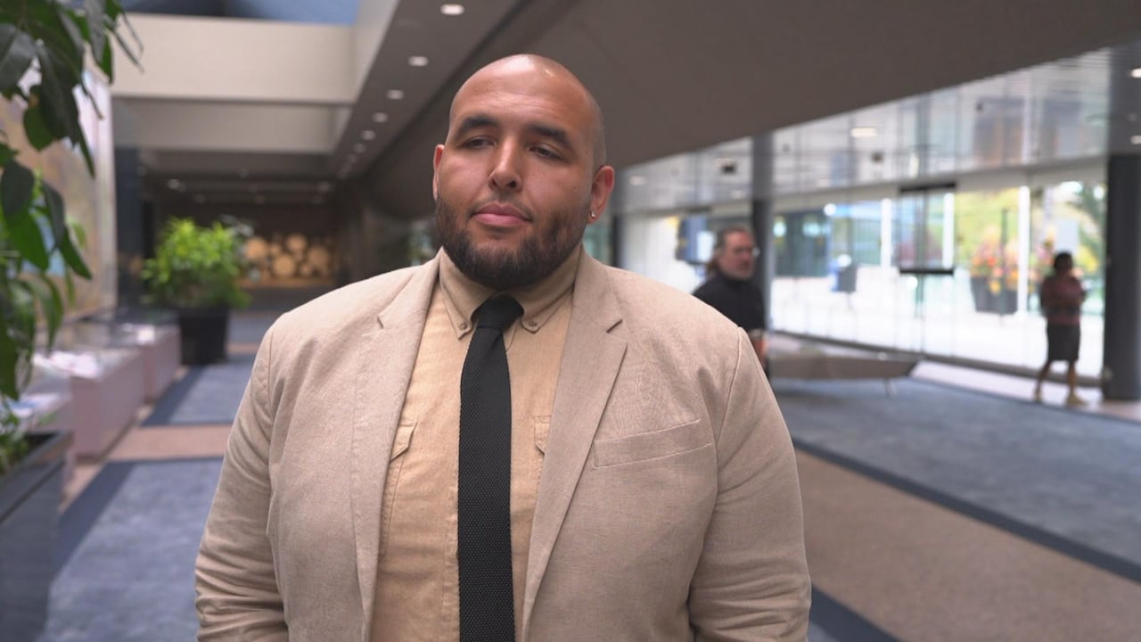 a man in a suit stands inside a building.