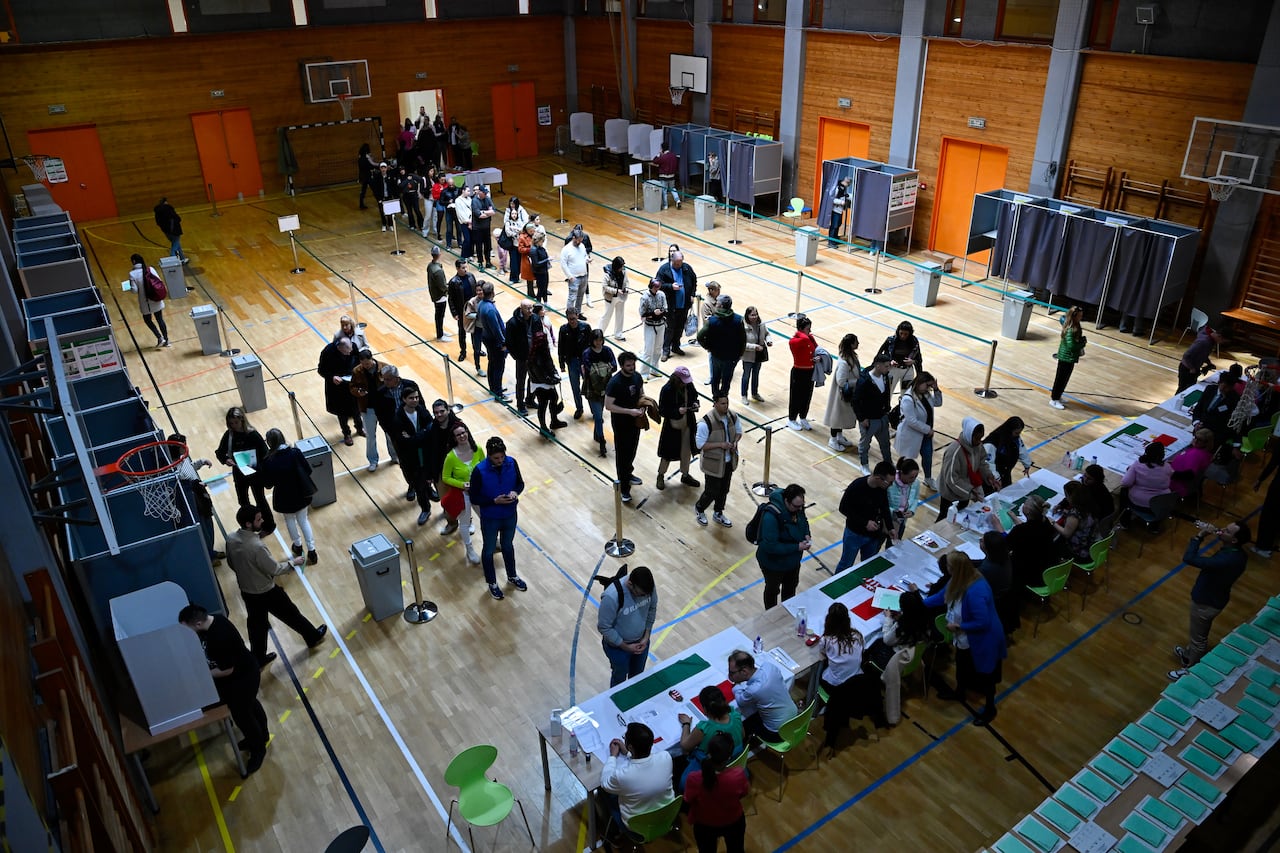 People stand in line at a polling station.