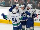 Vancouver Canucks center Teddy Blueger celebrates with teammates after scoring a goal.