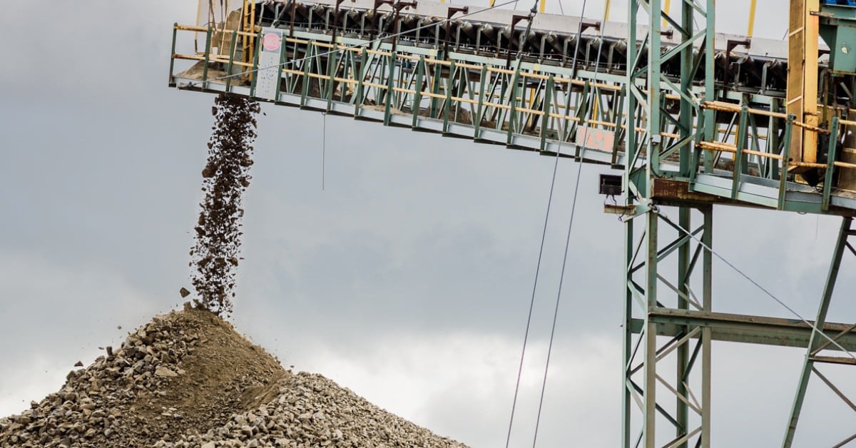 Rocks fall off a conveyor belt onto a pile in a quarry. 