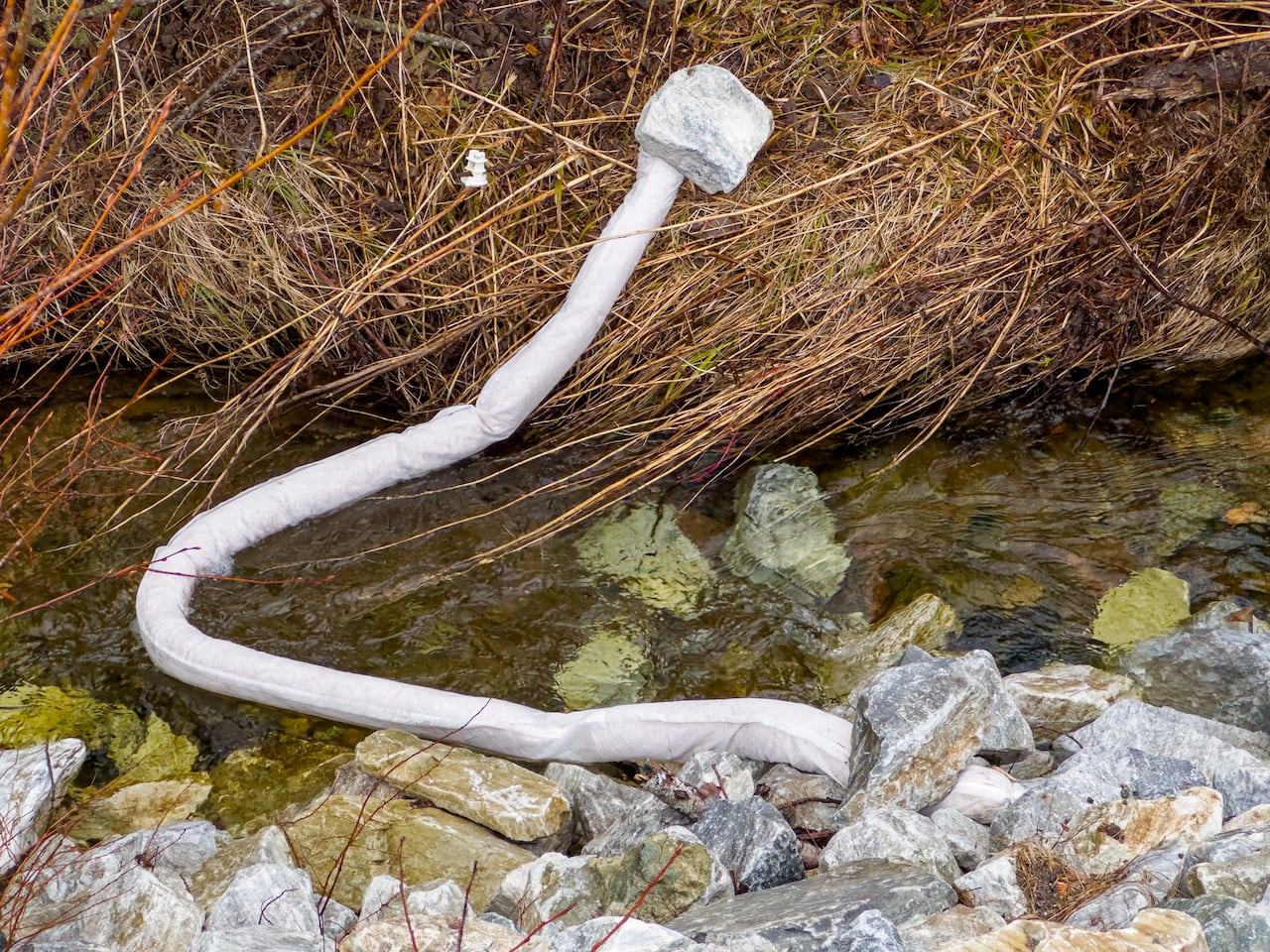 A long white sandbag on a brook