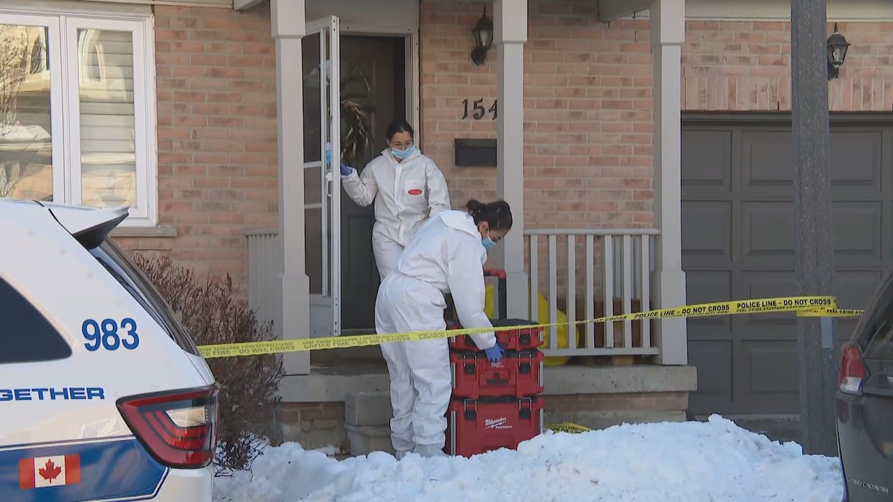 Investigators in hazmat suits bring equipment into a home behind a police line in Mississauga, where a 19-year-old died after bein shot by police.