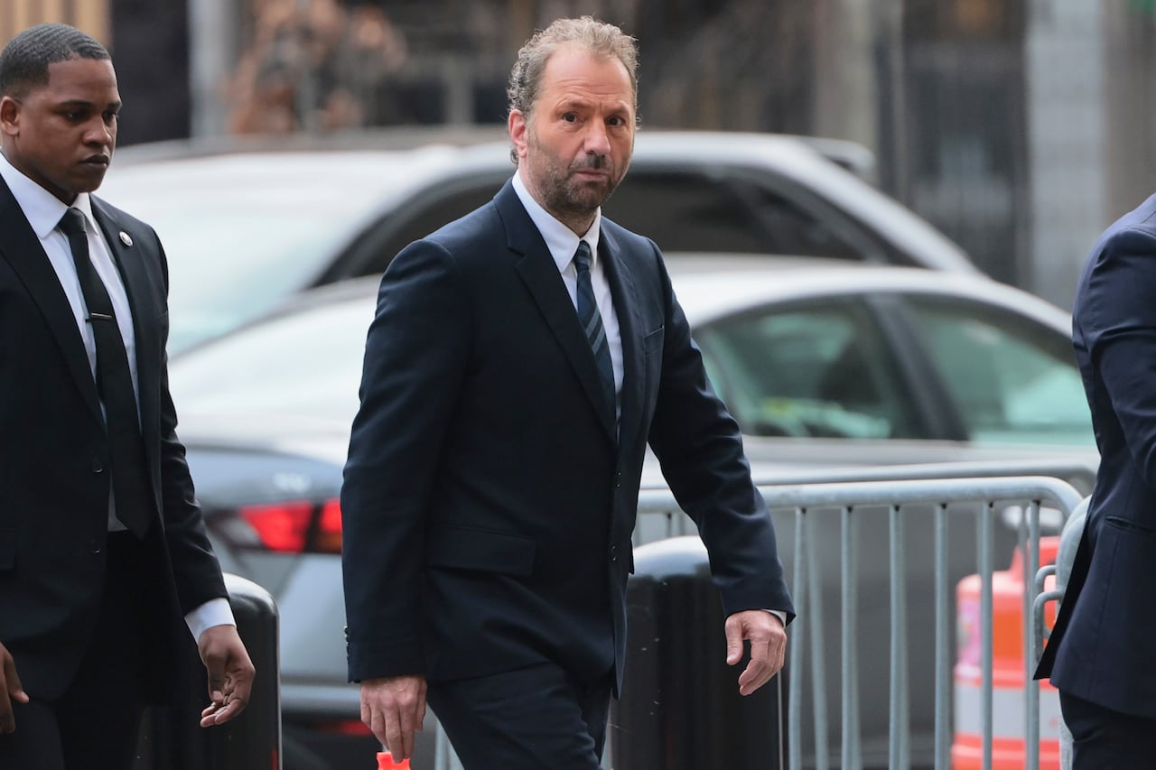 A man in a suit walks down a street.