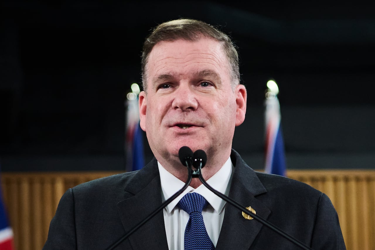 A man speaks into a microphone at a podium.