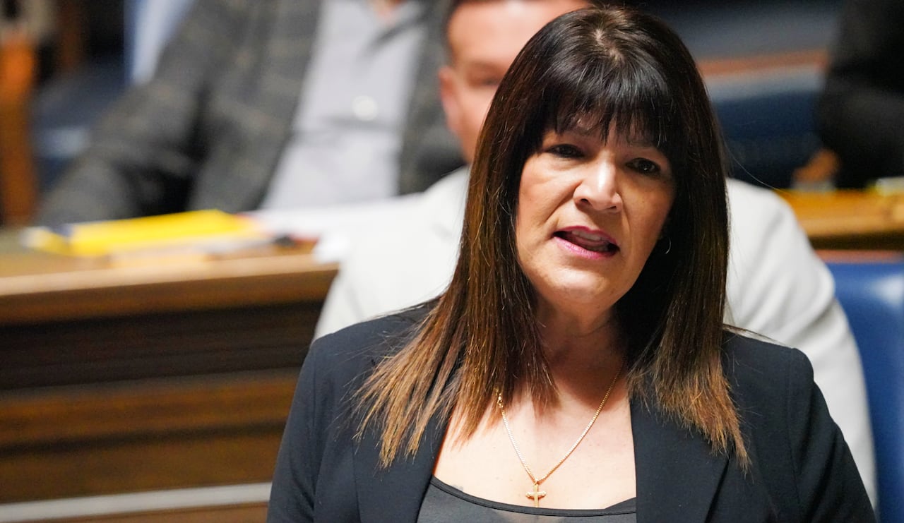 A woman in all black speaks during a government legislative session.