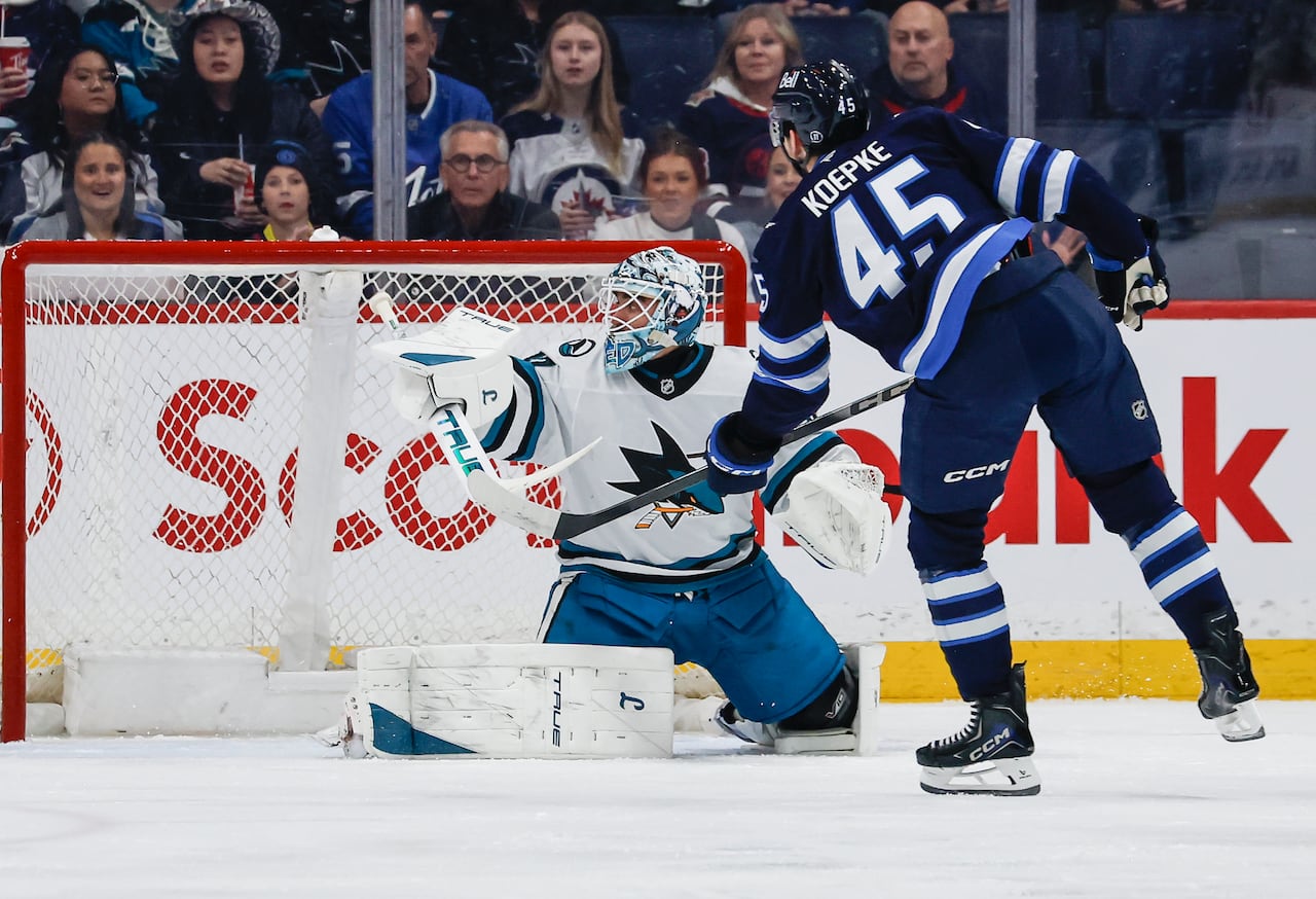 A Winnipeg player shoots past the blocker side of San Jose's goalie.