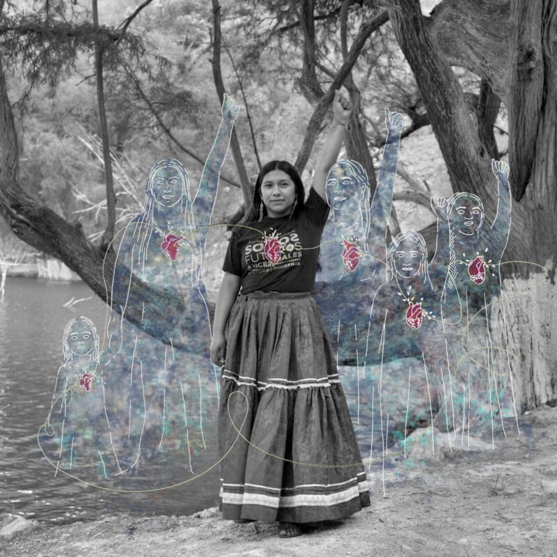 A woman stands by a river with one fist raised, wearing a skirt and t-shirt. Superimposed are ethereal, hand-drawn figures also raising their fists, creating an empowering, dreamlike effect. Trees and water fill the background.