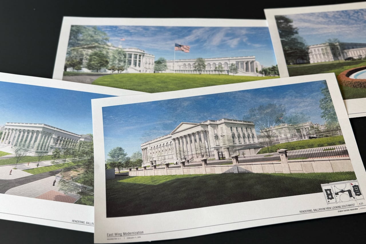 Multiple pages of rendered art are seen on a table.