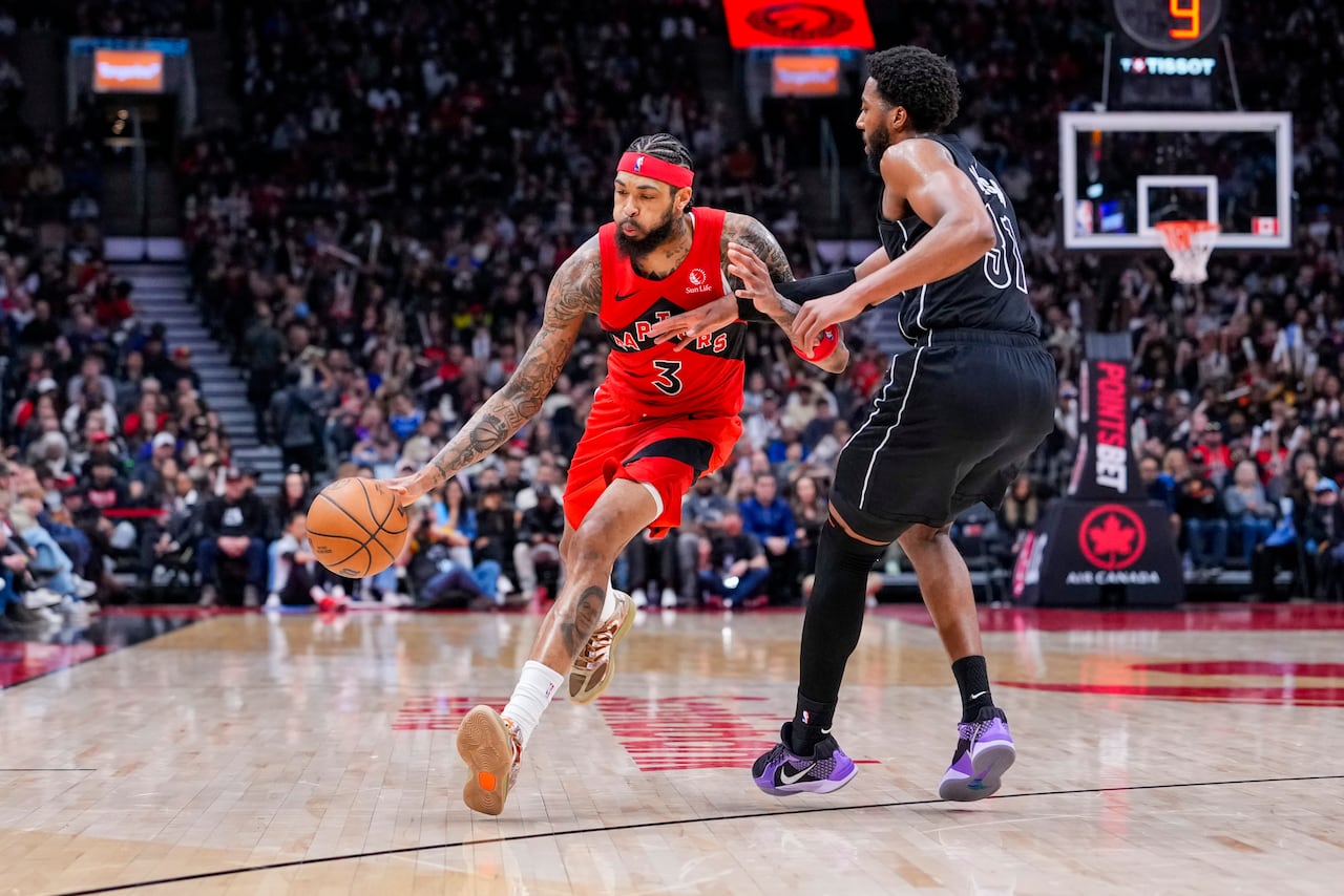 Toronto Raptors forward Brandon Ingram dribbles the ball, while being guarded by Chaney Johnson of the Brooklyn Nets