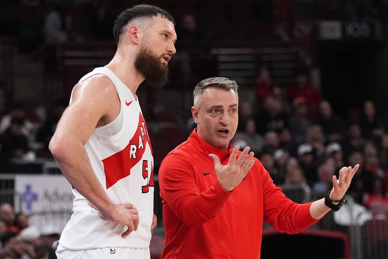 Raptors head coach Darko Rajaković speaks to forward Sandro Mamukelashvili during a game