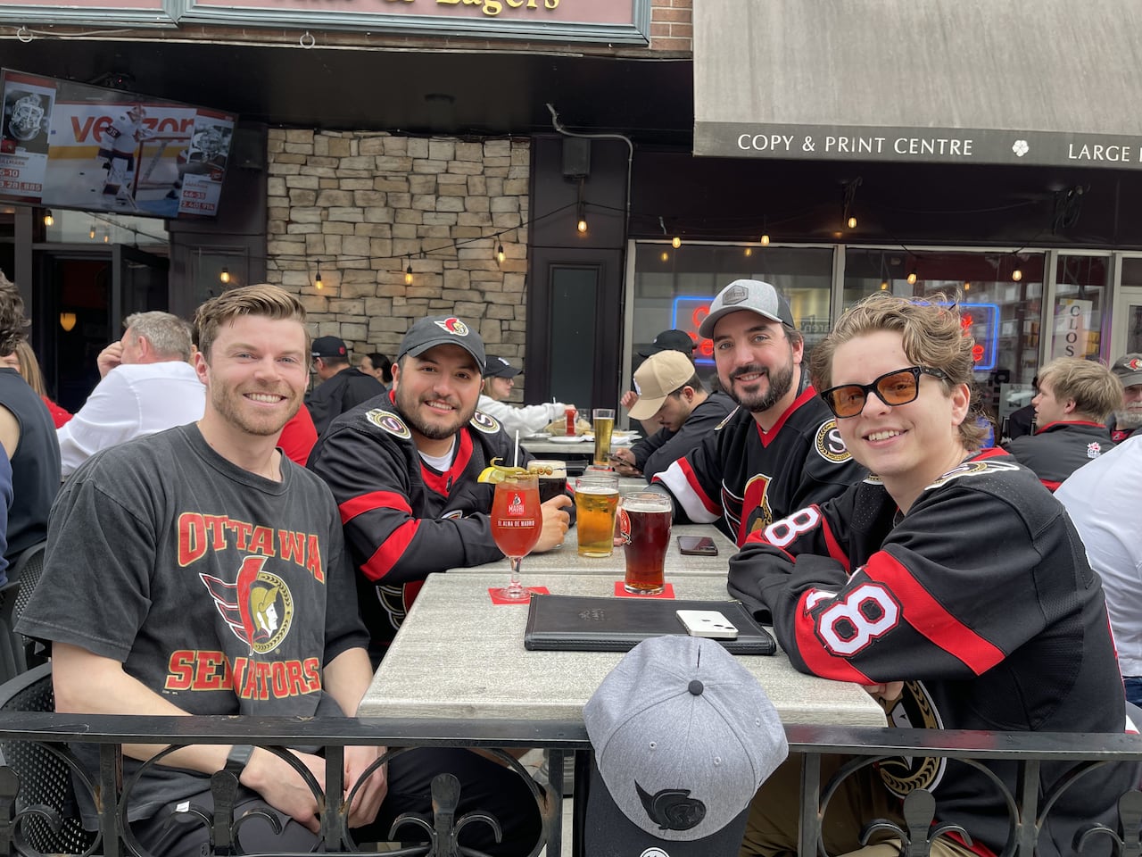 Men sit in Senators jerseys outside a pub in downtown Ottawa.
