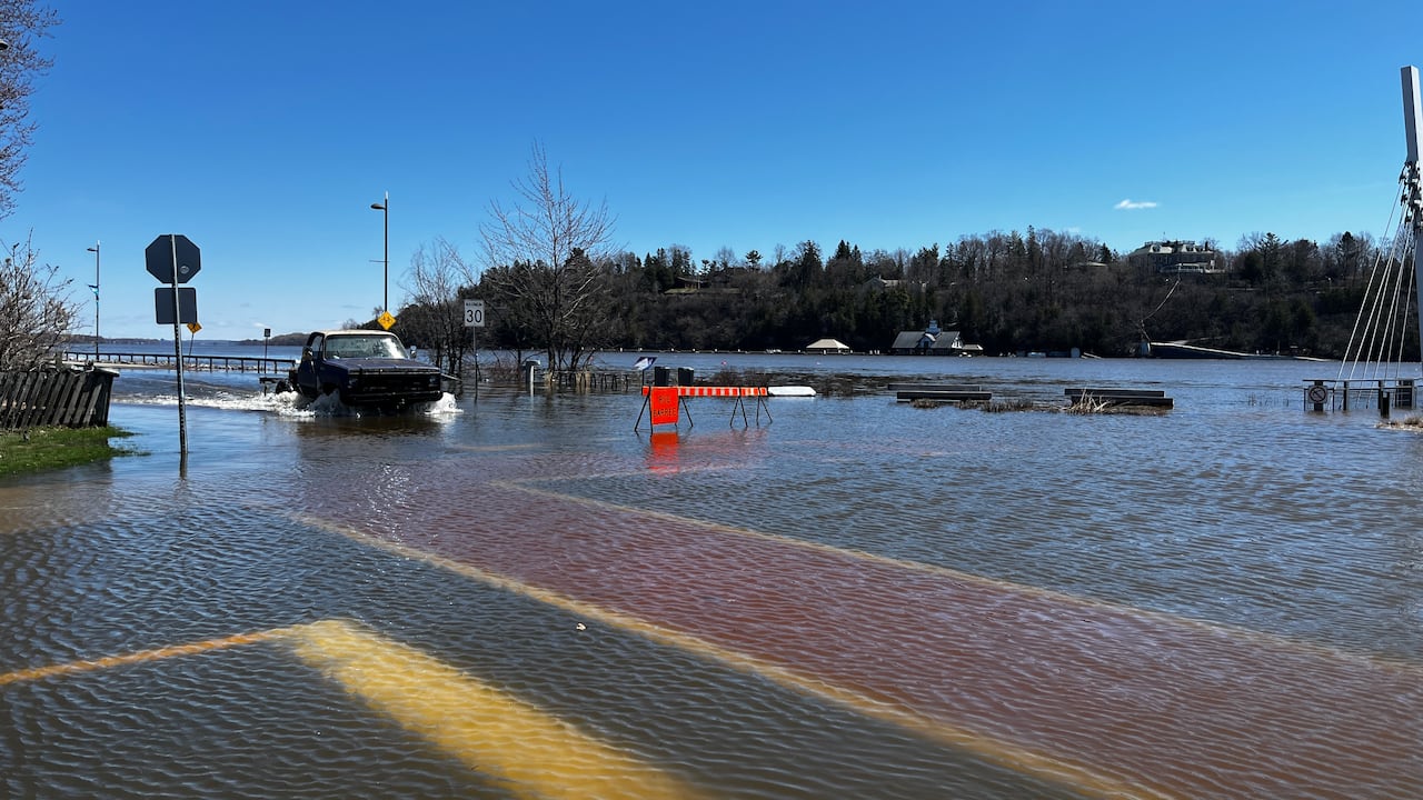 Several centimetres of water cover a city intersection on a sunny spring day.