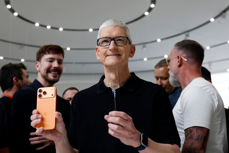 Apple CEO Tim Cook holds an iPhone 17.