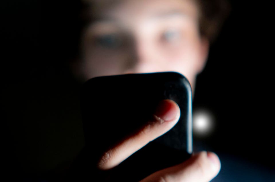 Man using phone in dark.