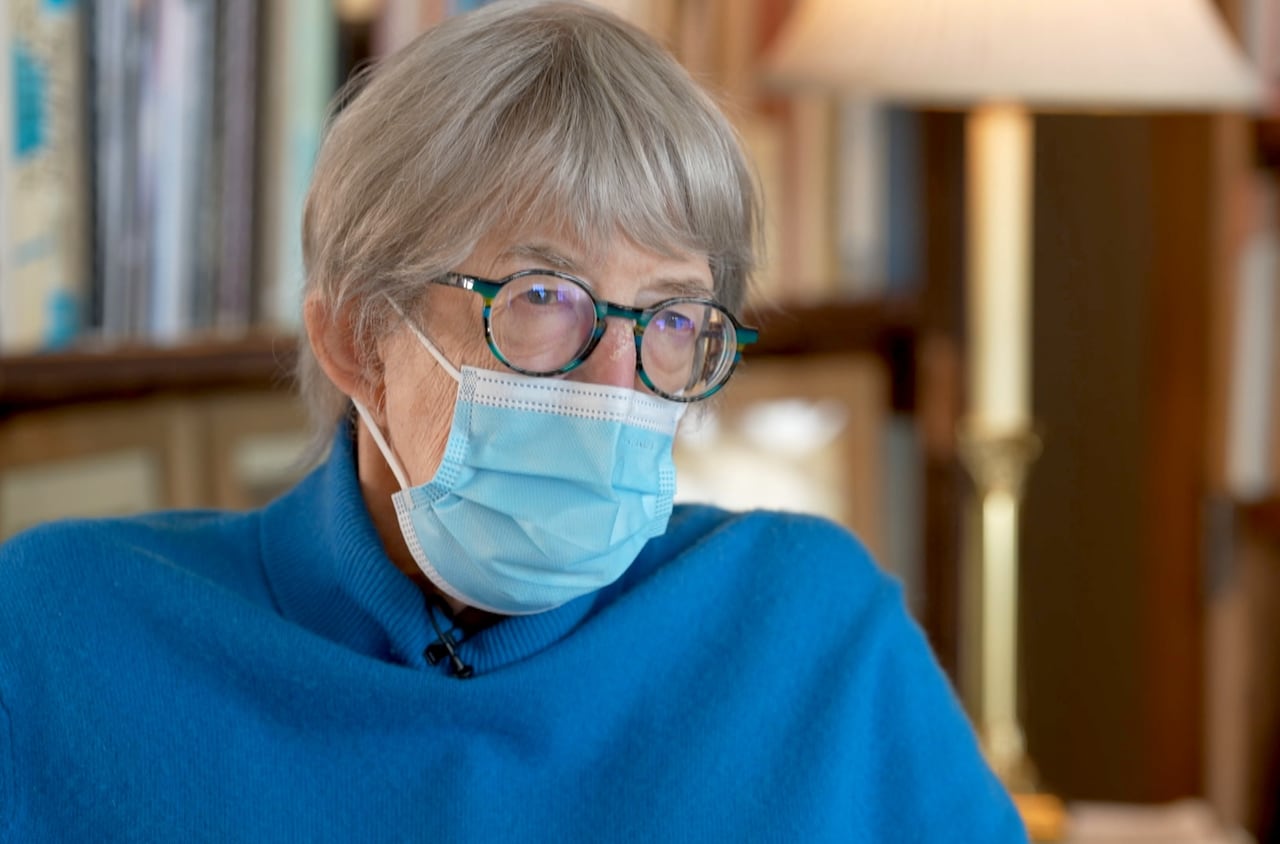 Brenda Roman wears a blue sweater and a mask.