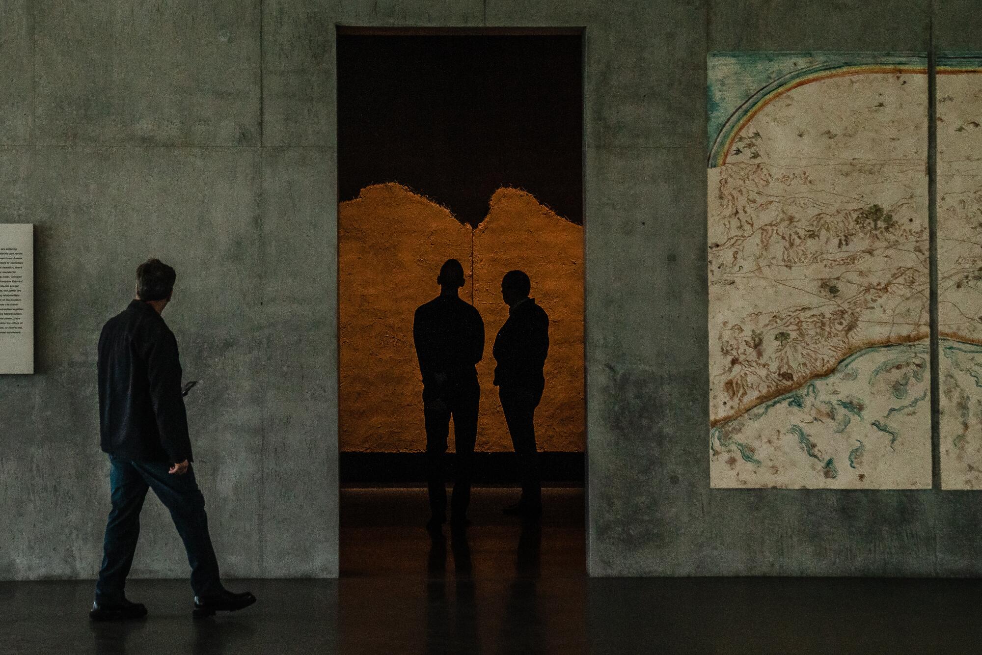 People wander inside a concrete museum.