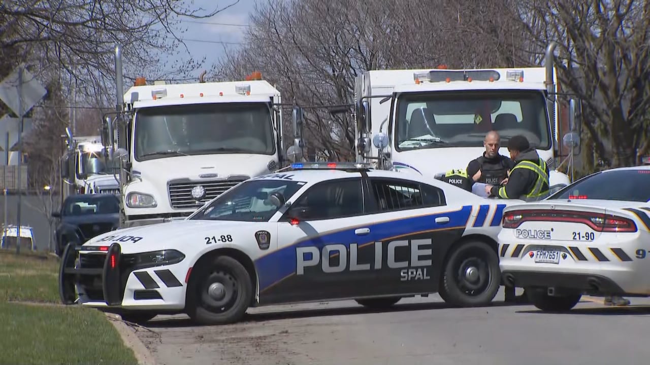 police cars and officers at the scene of someone's death in a residential neighbourhood.