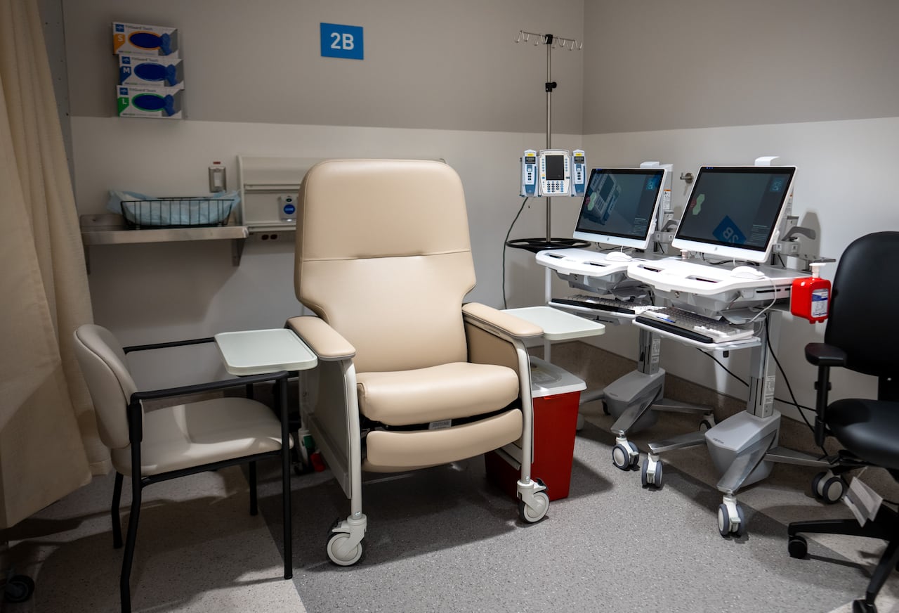 A hospital chair is seen next to monitors and equipment.