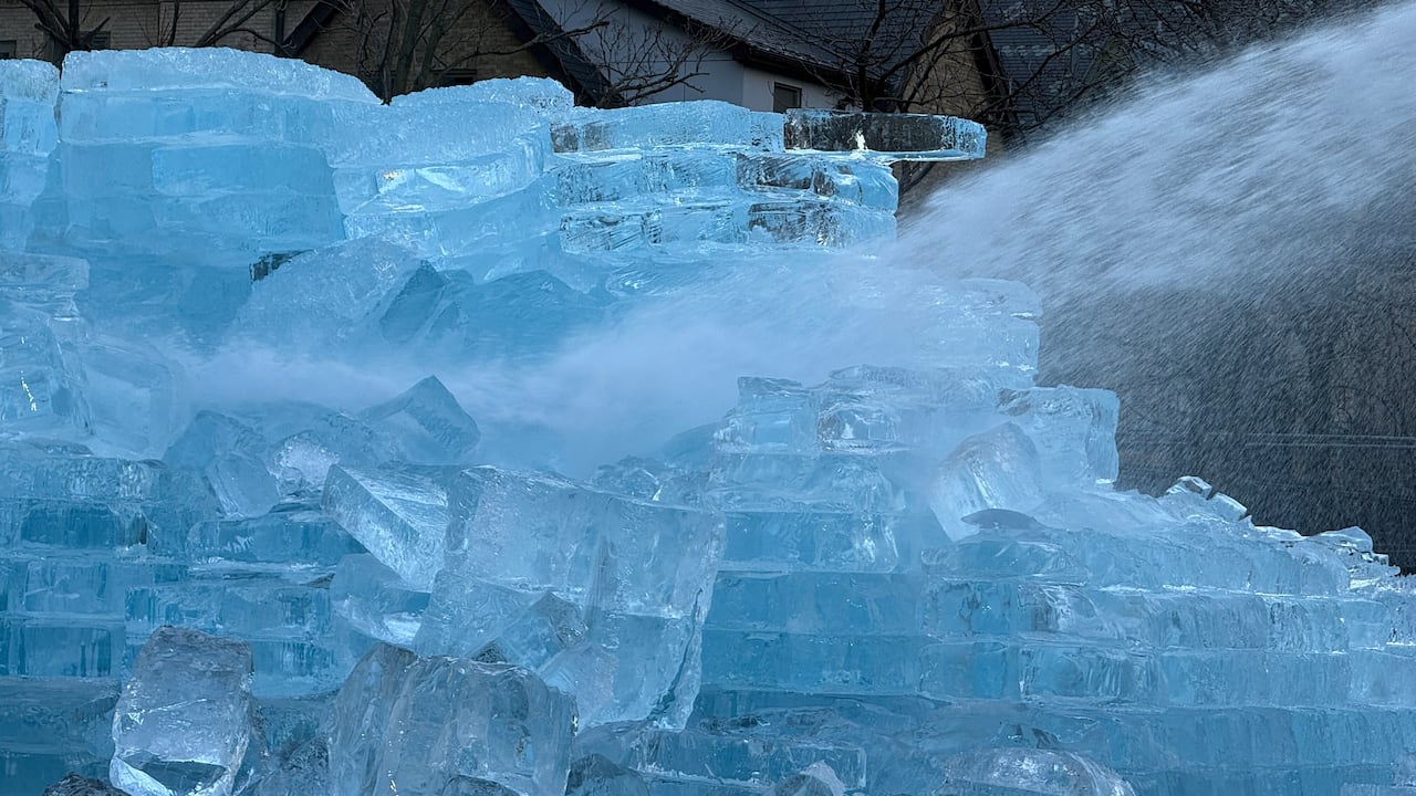 closeup photo of wtaer spraying on large blocks of ice