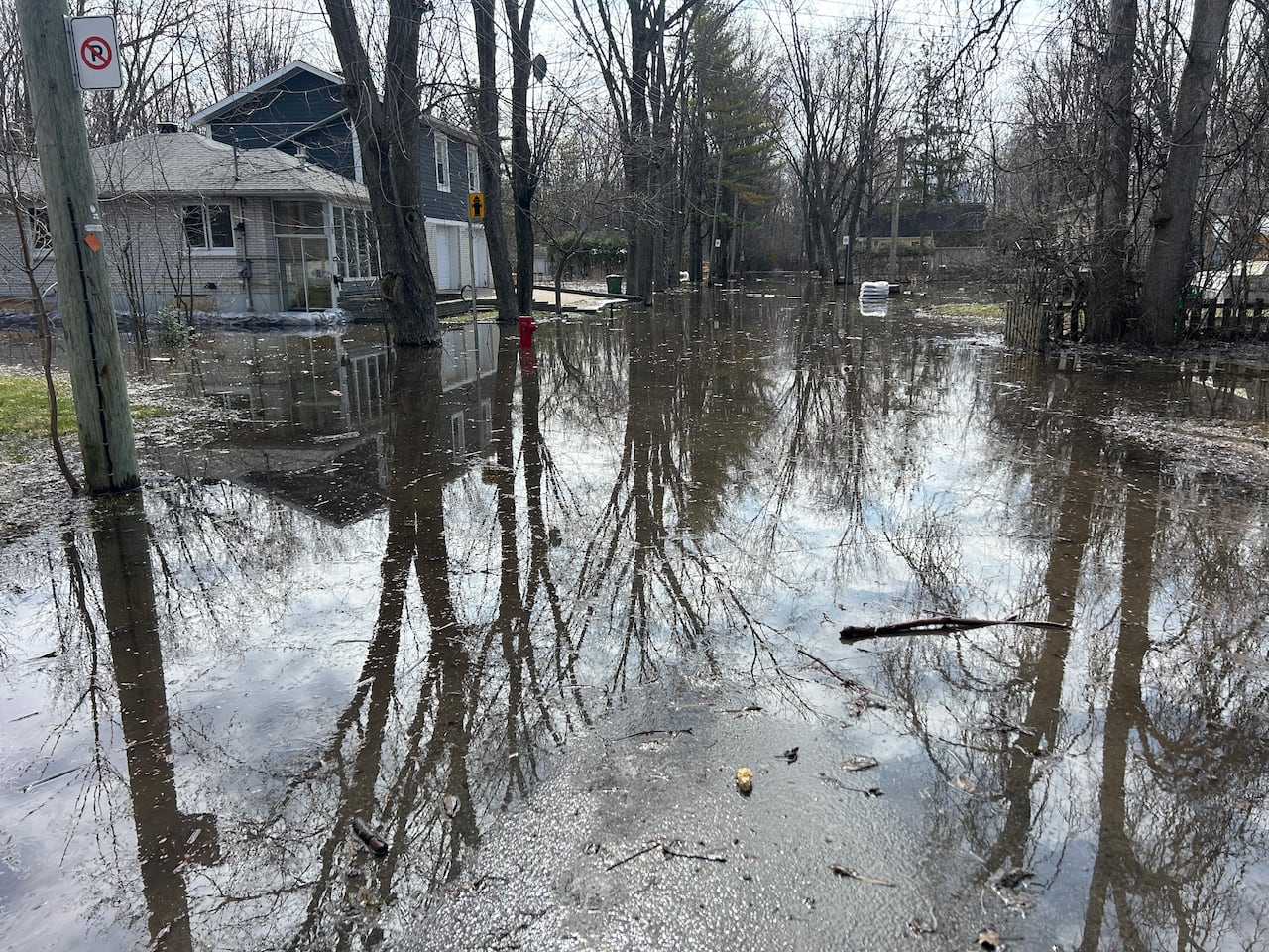 A large amount of water covers the road and area surrounding a home