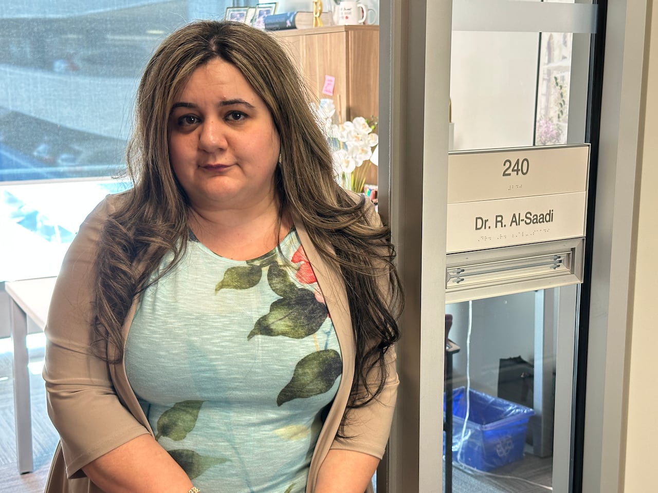 A woman standing next to a door.
