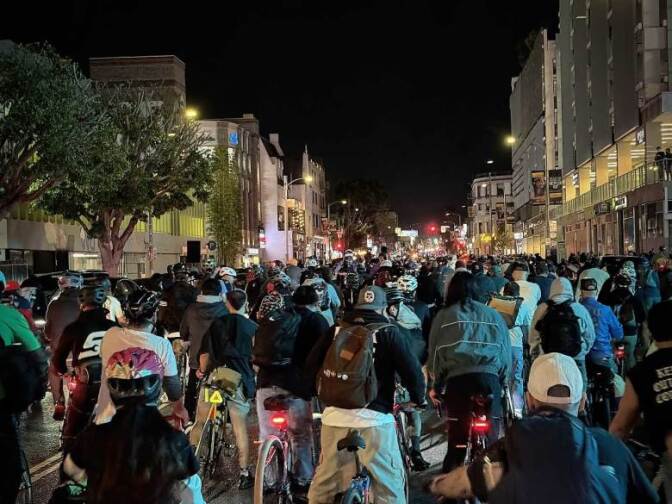 Thousands of bike riders fill a street.