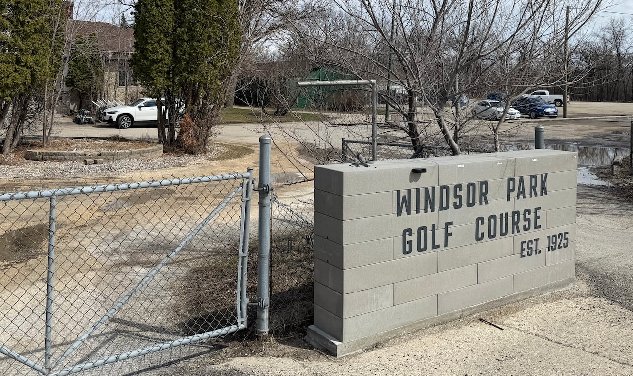 A fence sits beside signage on a low concrete wall reading "Windsor Park Golf Course, Est. 1925."