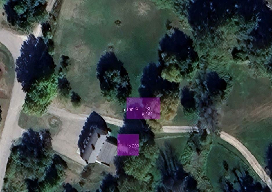 An aerial Google Earth screengrab of a property with a house, green grass and large green trees has three small purple squares superimposed over it.