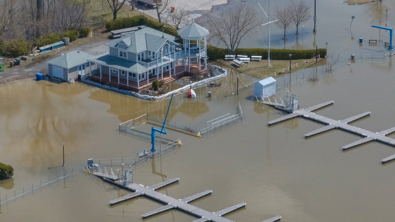 An aerial shot of water from a river spilling its banks and flooding a marina.