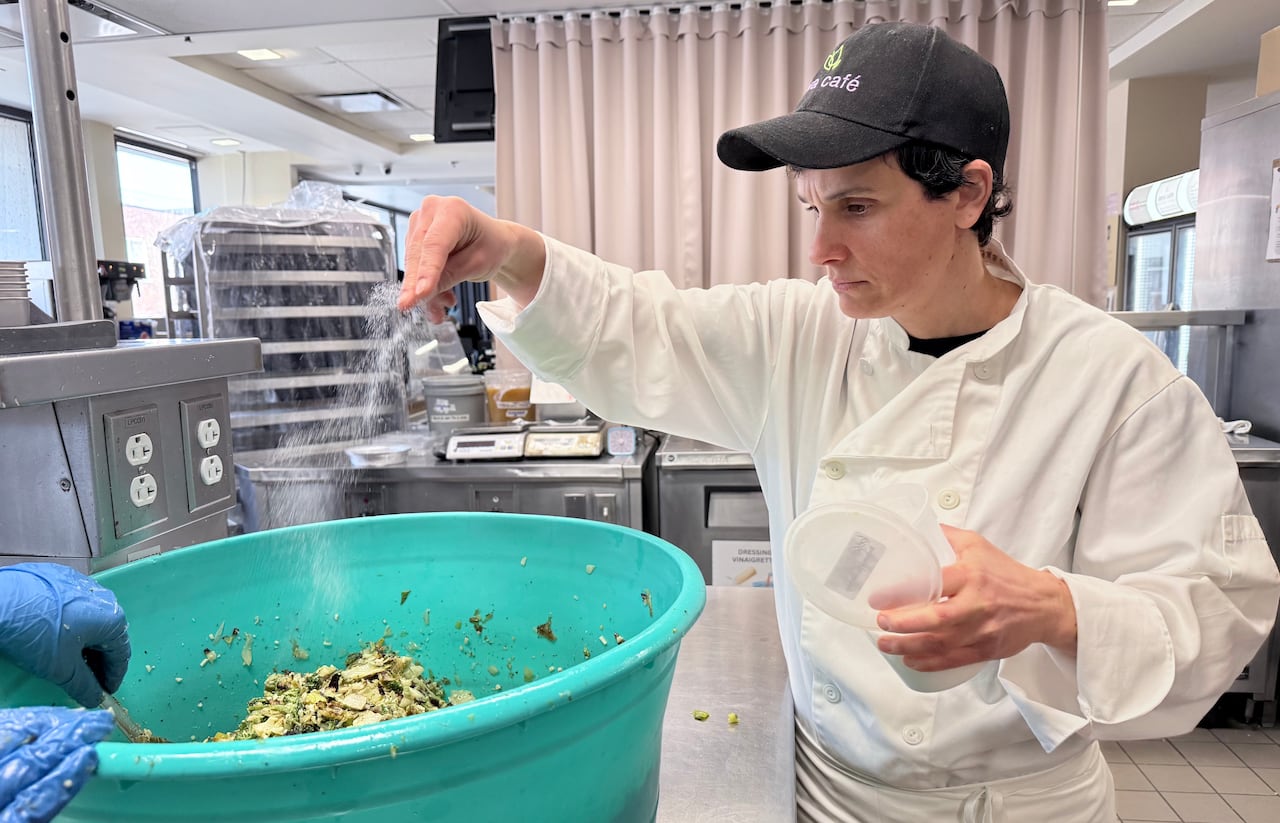 woman adds spice to food in restaurant
